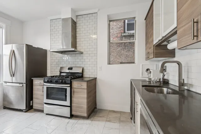 a kitchen with stainless steel appliances granite countertop a sink stove and refrigerator