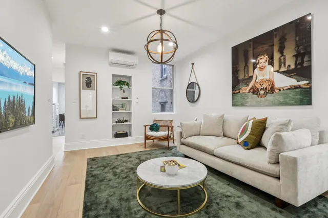 a living room with furniture a rug and white walls