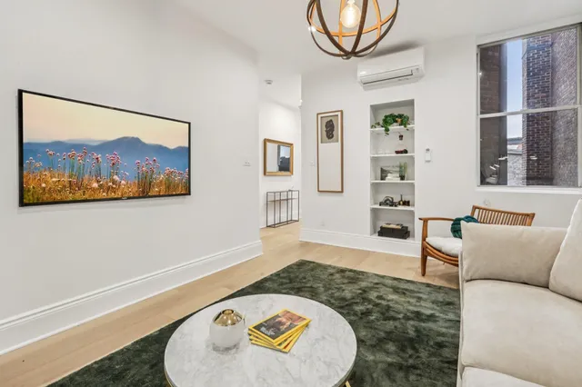 a living room with furniture and a wall painting