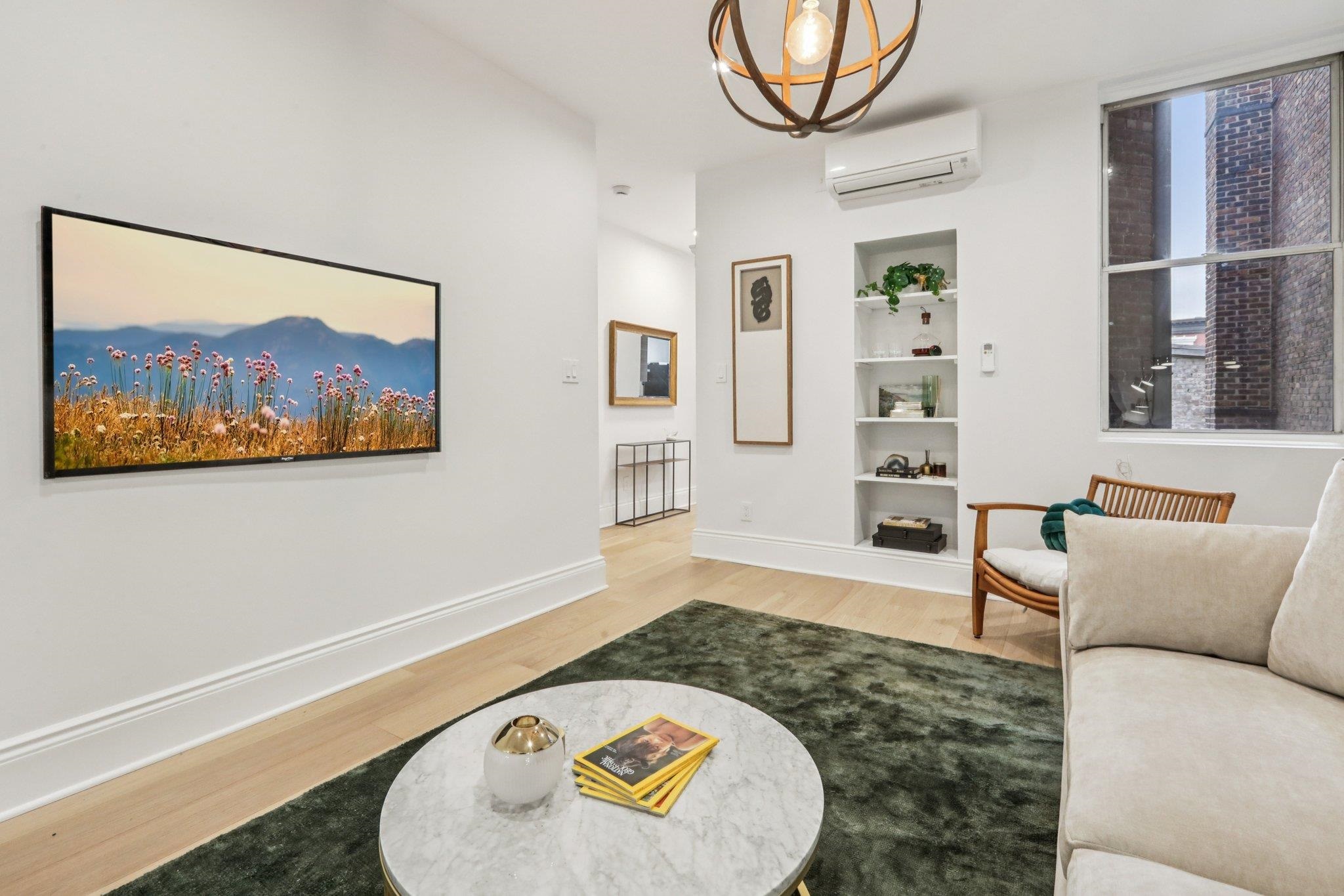 97 Clifton Terrace, Unit 6 Weehawken, NJ 07086 - Photo 6 of 36 a living room with furniture and a wall painting