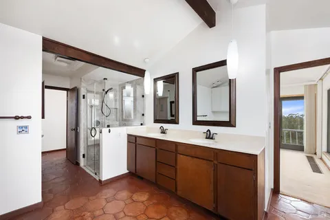 a spacious bathroom with a double vanity sink a mirror and a shower