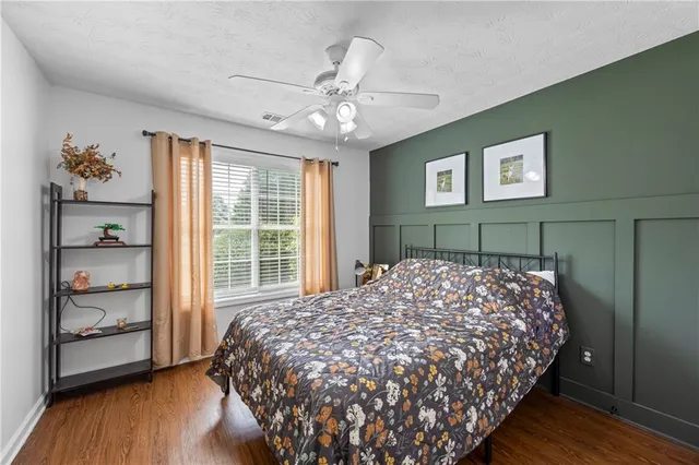 a bedroom with bed and wooden floor