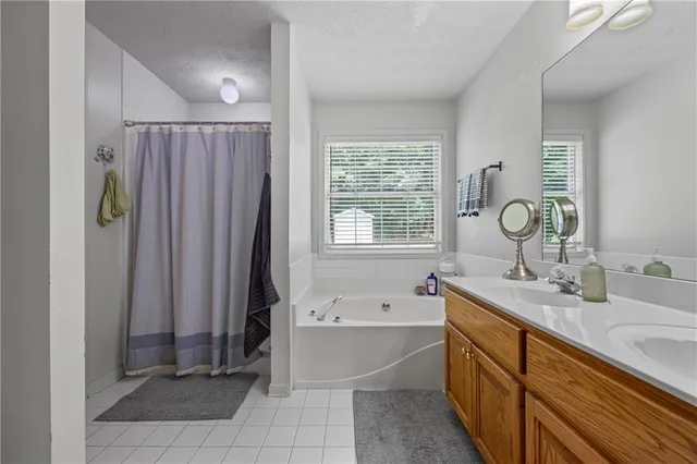 a bathroom with a tub sink and mirror