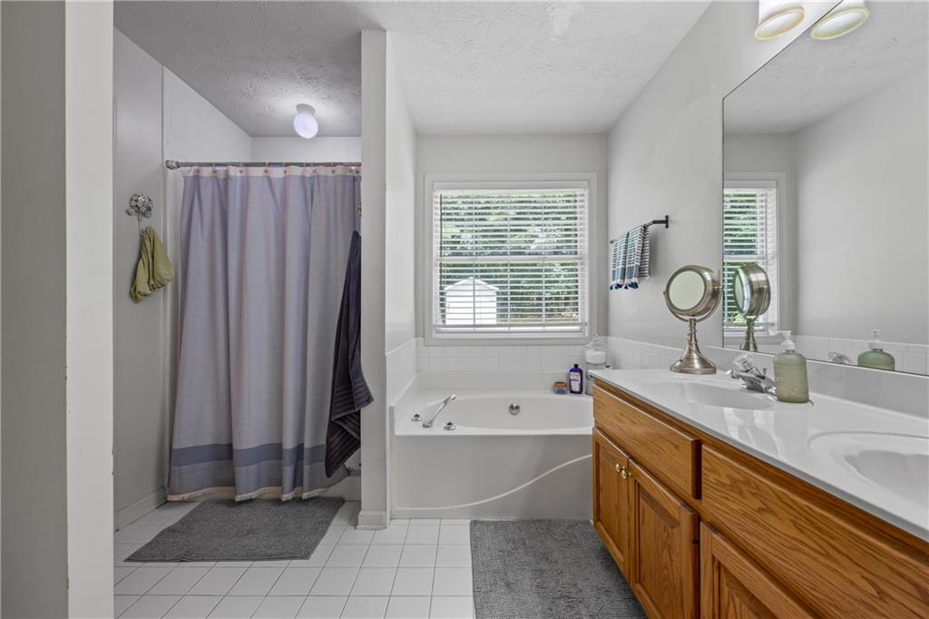 2630 Track Way Dacula, GA 30019 - Photo 20 of 27 a bathroom with a tub sink and mirror