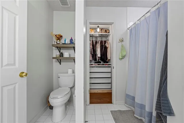 a bathroom with a toilet and a shower curtain