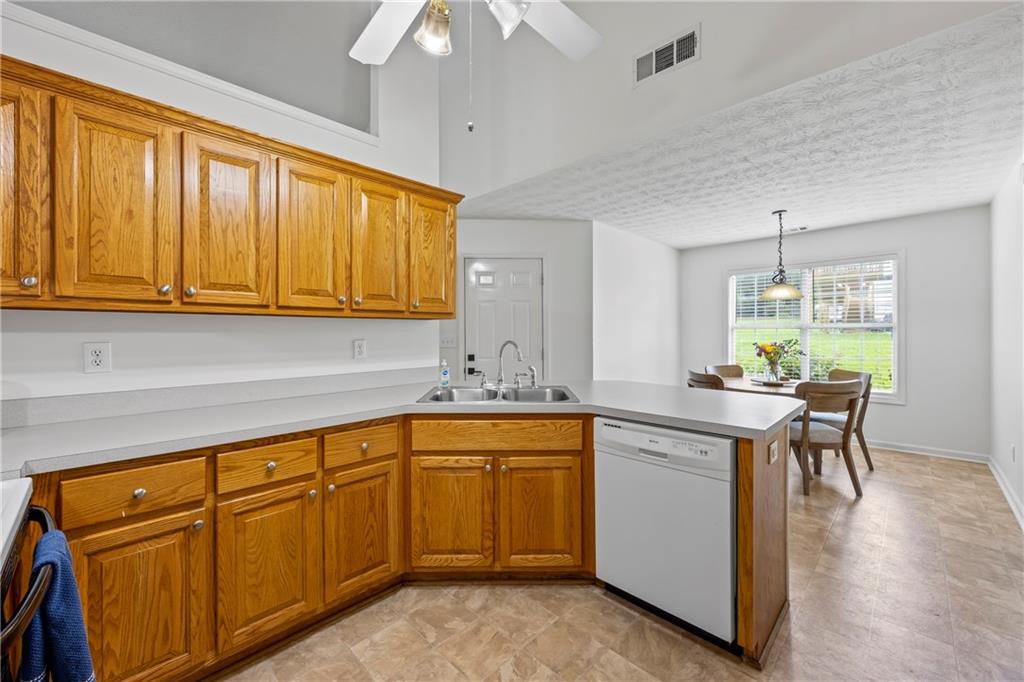 2630 Track Way Dacula, GA 30019 - Photo 6 of 27 a kitchen with stainless steel appliances granite countertop wooden cabinets a dining table and chairs