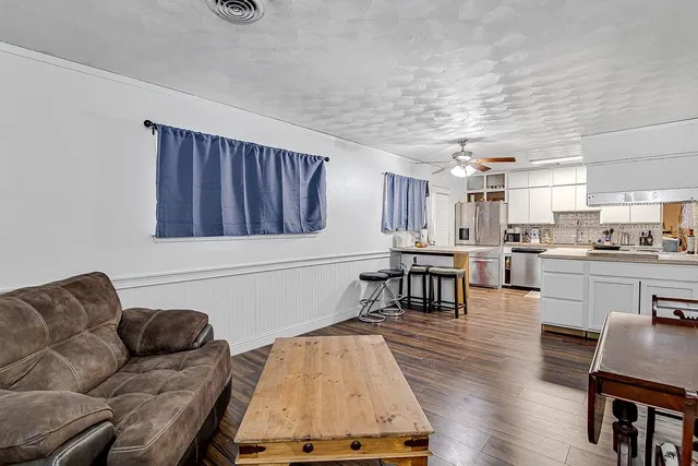 a living room with furniture and kitchen view