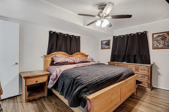 a bedroom with bed and wooden floor