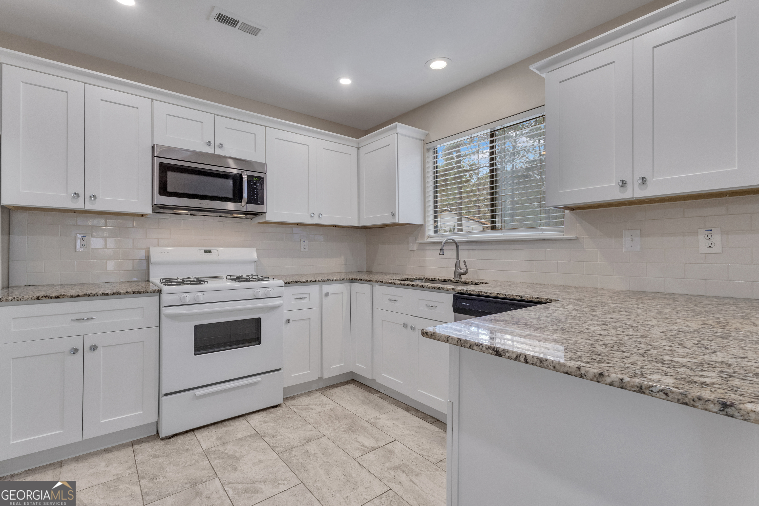 101 Dove Rise Peachtree City, GA 30269 - Photo 12 of 41 a kitchen with granite countertop white cabinets white stainless steel appliances and a sink
