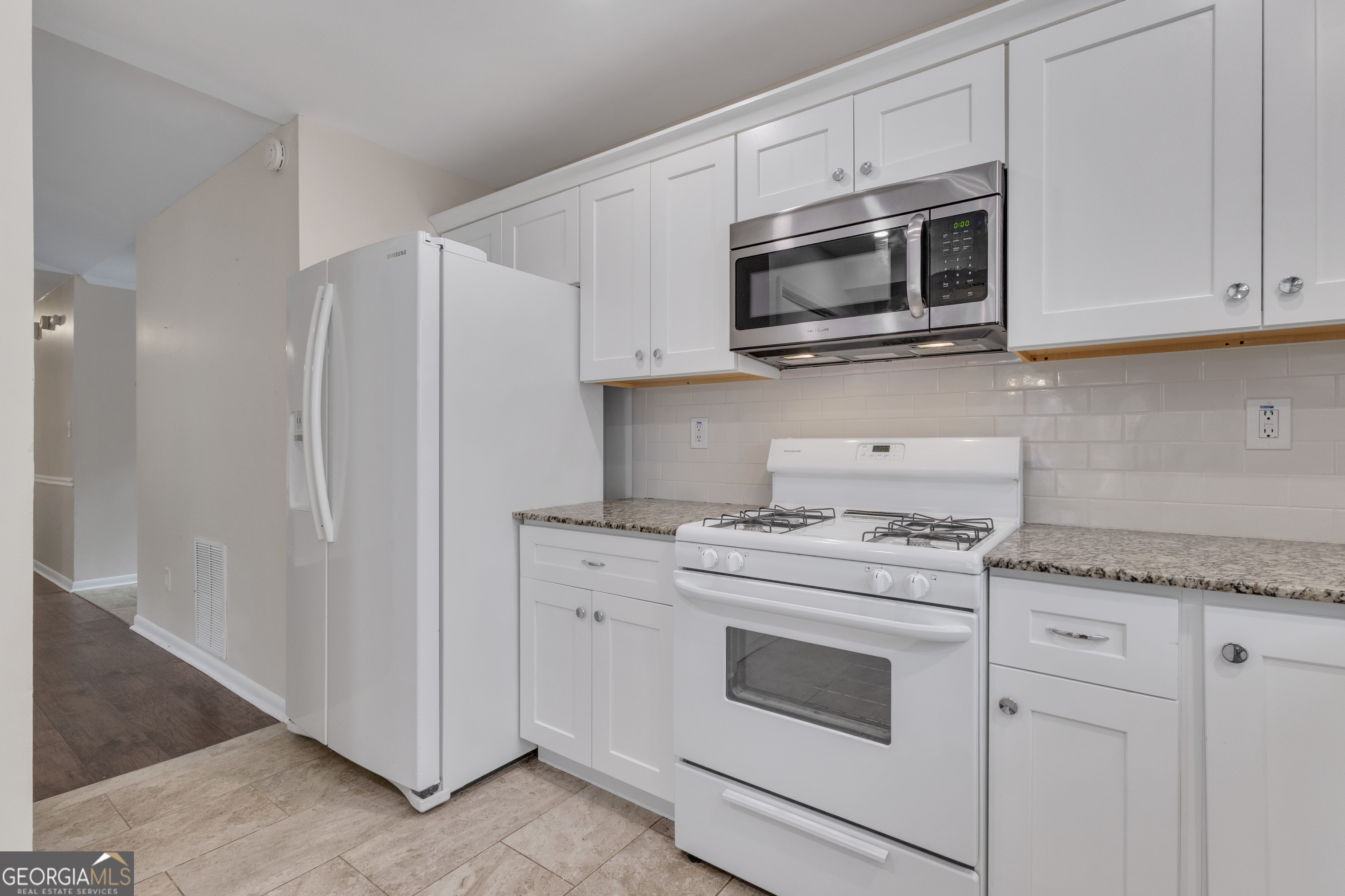 101 Dove Rise Peachtree City, GA 30269 - Photo 13 of 41 a kitchen with stainless steel appliances granite countertop white cabinets and a stove a oven with white countertops
