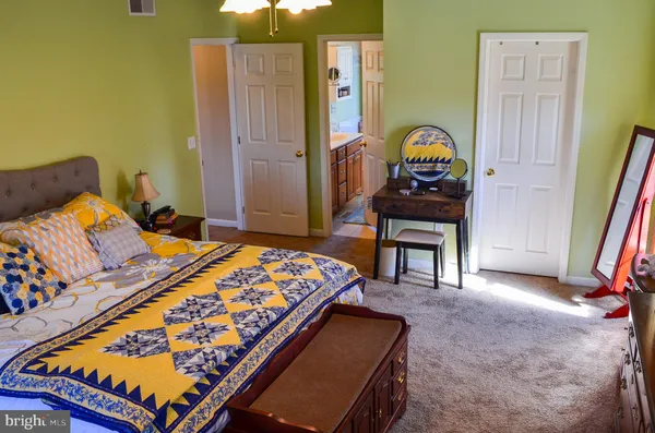 a bedroom with a bed and a dresser next to a window