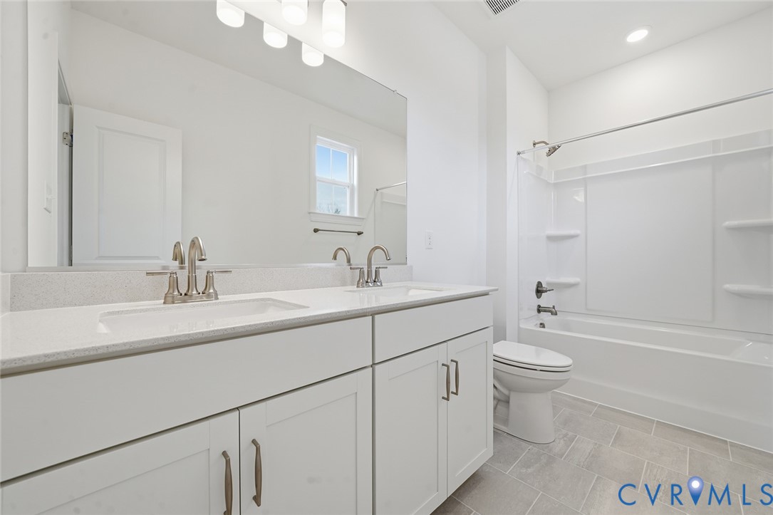 19025 Palisades Ridge Moseley, VA 23120 - Photo 17 of 41 a bathroom with a double vanity sink a toilet and a bathtub