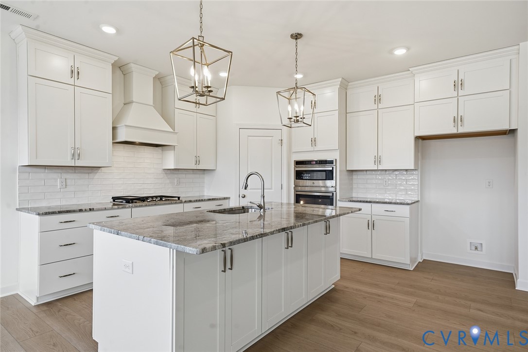 19025 Palisades Ridge Moseley, VA 23120 - Photo 2 of 41 a kitchen with white cabinets stainless steel appliances and wooden floor
