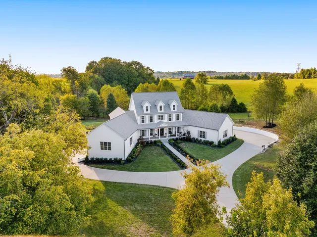 an aerial view of a house with garden space and a ocean view