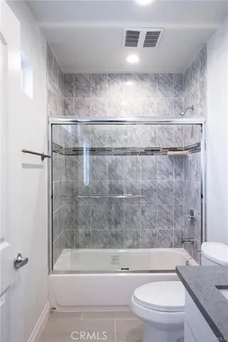 a bathroom with a bathtub and a white toilet