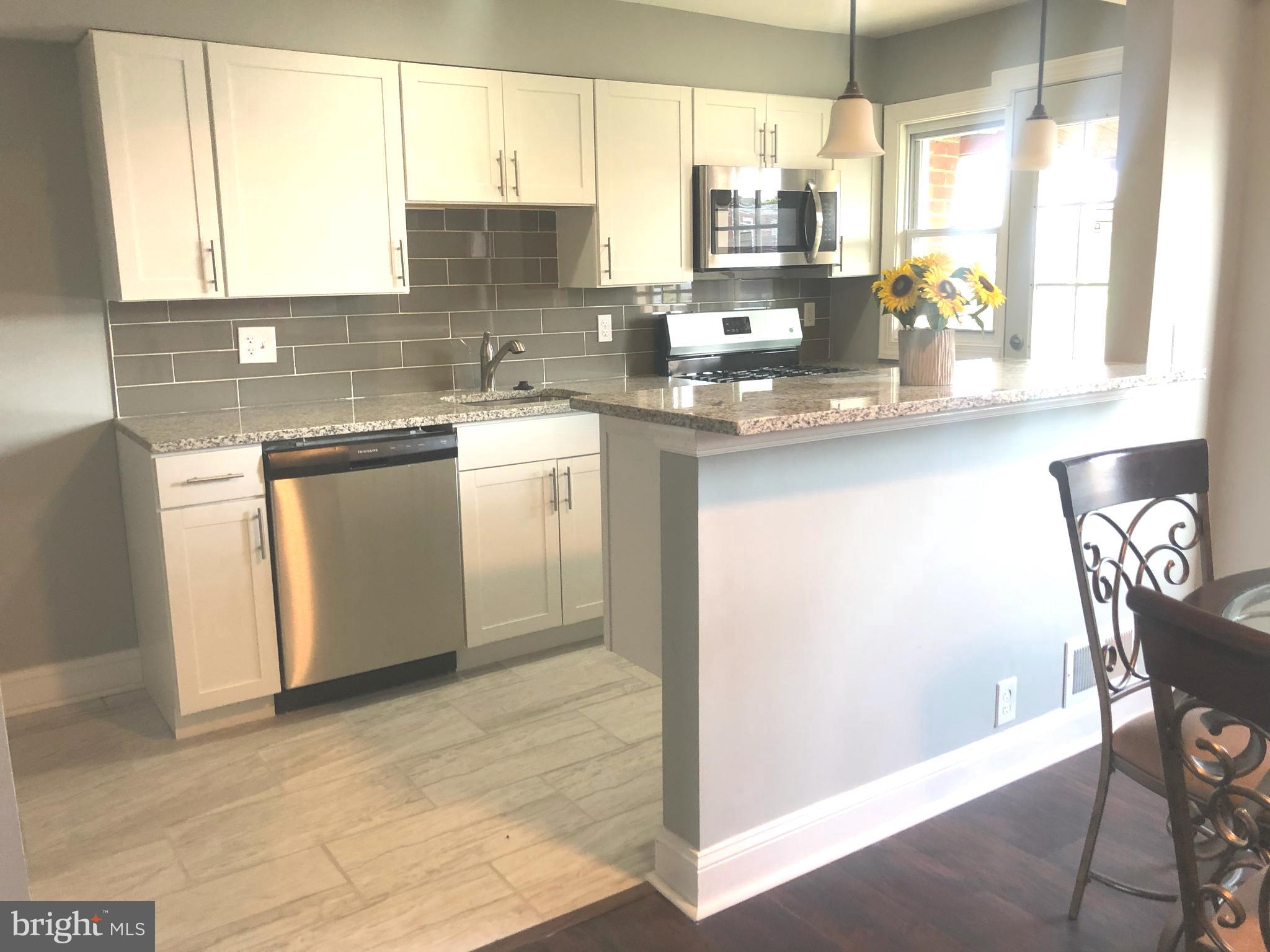 7441 Edsworth Road Baltimore, MD 21222 - Photo 6 of 37 a kitchen with granite countertop a stove a sink and a counter space