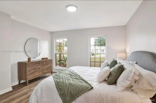 a bedroom with a large bed and wooden floor