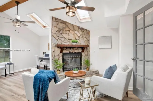 a living room with furniture a fireplace and a chandelier