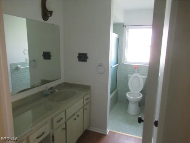 a bathroom with a granite countertop sink a toilet and a mirror