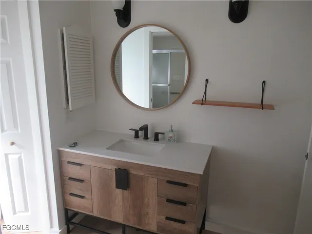 a bathroom with a sink vanity and a mirror