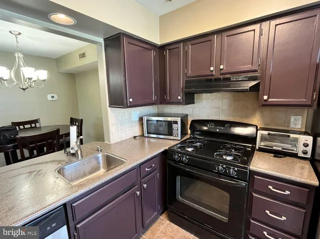 a kitchen with wooden cabinets a stove and a sink