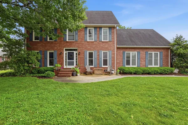 a front view of a house with yard and green space