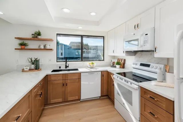 a kitchen with cabinets a window and stainless steel appliances