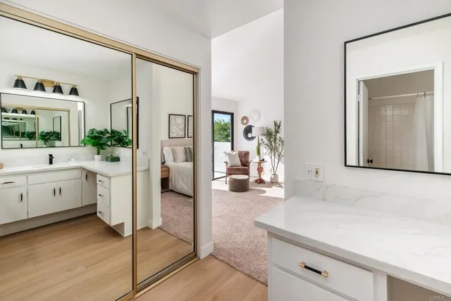 a hallway with white cabinets and wooden floor