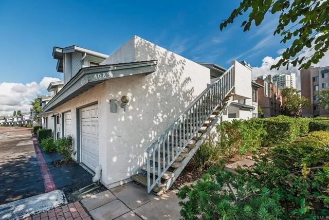 a view of a large building with a yard and potted plants