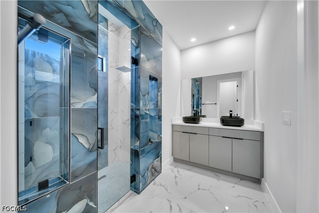 1128 Nelson Road North Cape Coral, FL 33993 - Photo 16 of 22 a bathroom with a double vanity sink mirror and shower