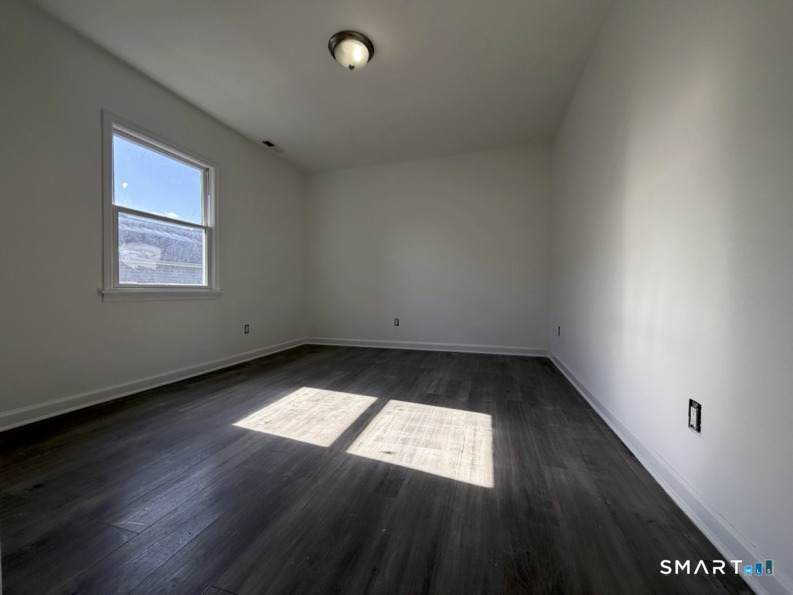 30 Dora Street Stamford, CT 06902 - Photo 12 of 18 an empty room with wooden floor and windows