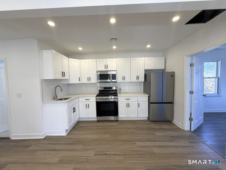 30 Dora Street Stamford, CT 06902 - Photo 4 of 18 a kitchen with stainless steel appliances granite countertop a refrigerator a stove a sink and a microwave