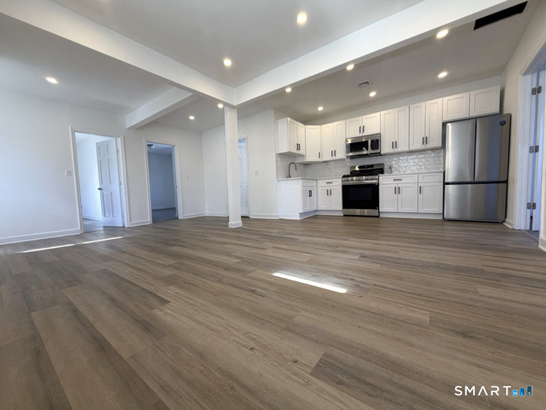 30 Dora Street Stamford, CT 06902 - Photo 5 of 18 an open kitchen with kitchen island a stove and a refrigerator