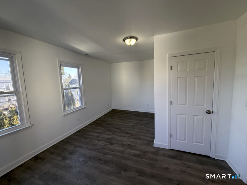 30 Dora Street Stamford, CT 06902 - Photo 6 of 18 an empty room with wooden floor and windows