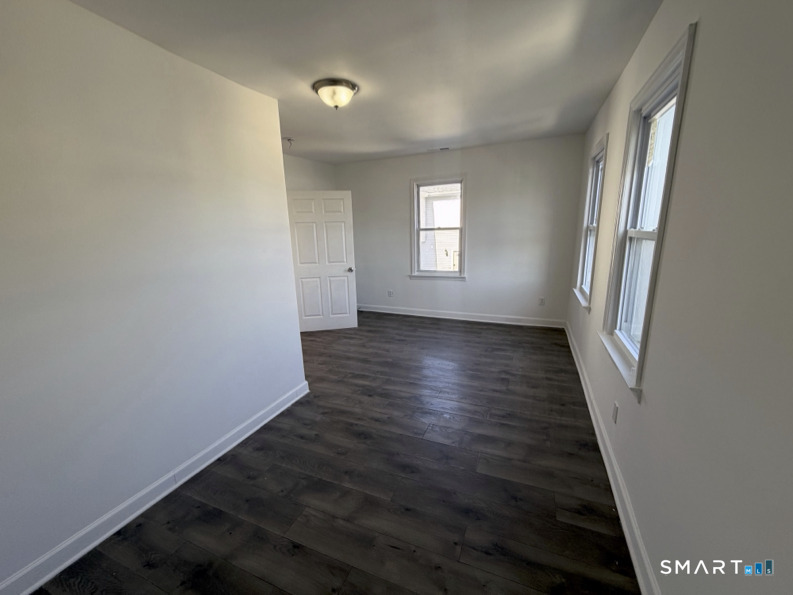30 Dora Street Stamford, CT 06902 - Photo 7 of 18 an empty room with wooden floor and windows