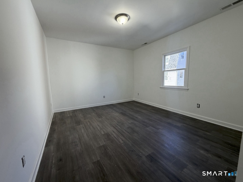 30 Dora Street Stamford, CT 06902 - Photo 10 of 18 an empty room with wooden floor and windows