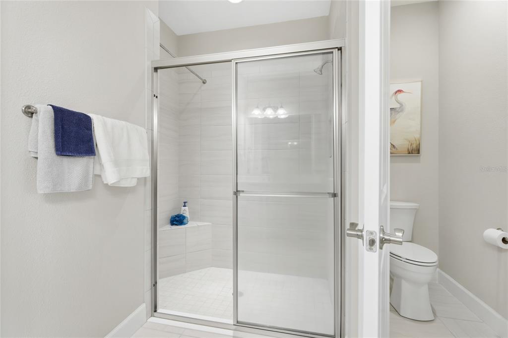 5804 Semolino Street Nokomis, FL 34275 - Photo 18 of 53 a bathroom with a glass shower door