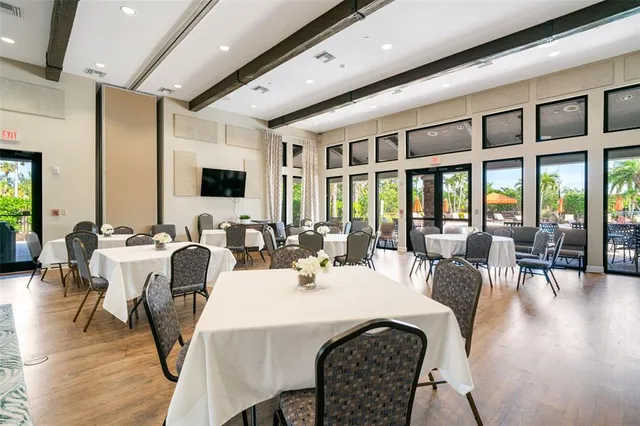 a kitchen with stainless steel appliances granite countertop a dining table chairs and chandelier