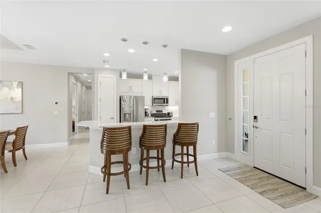a kitchen with refrigerator and chairs