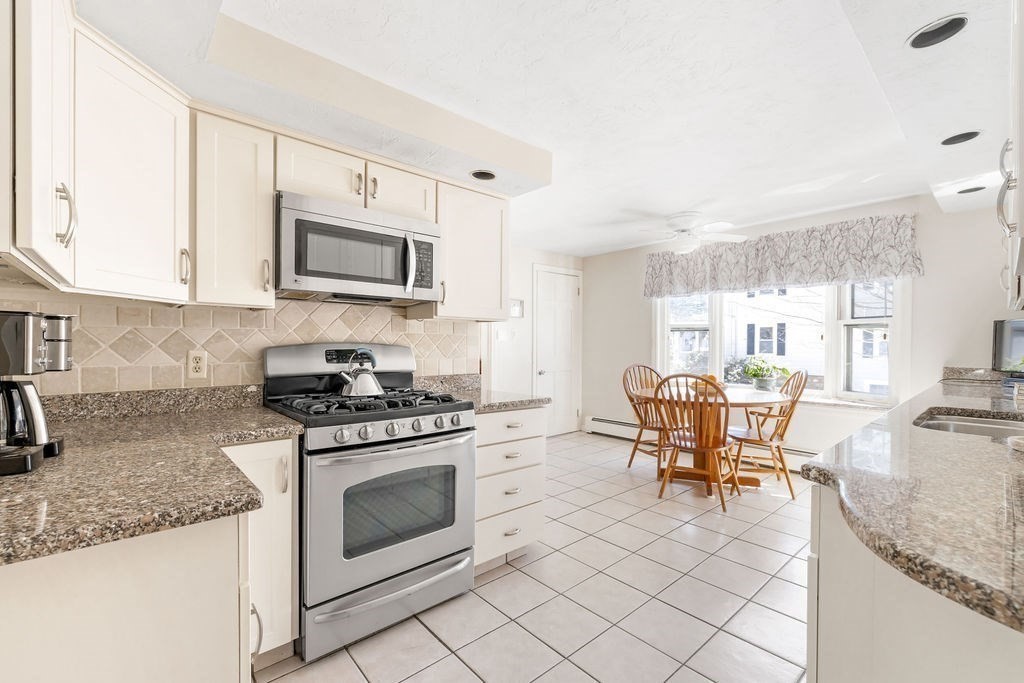 60 High Street Needham, MA 02494 - Photo 13 of 32 a kitchen with granite countertop cabinets stainless steel appliances and a counter top space