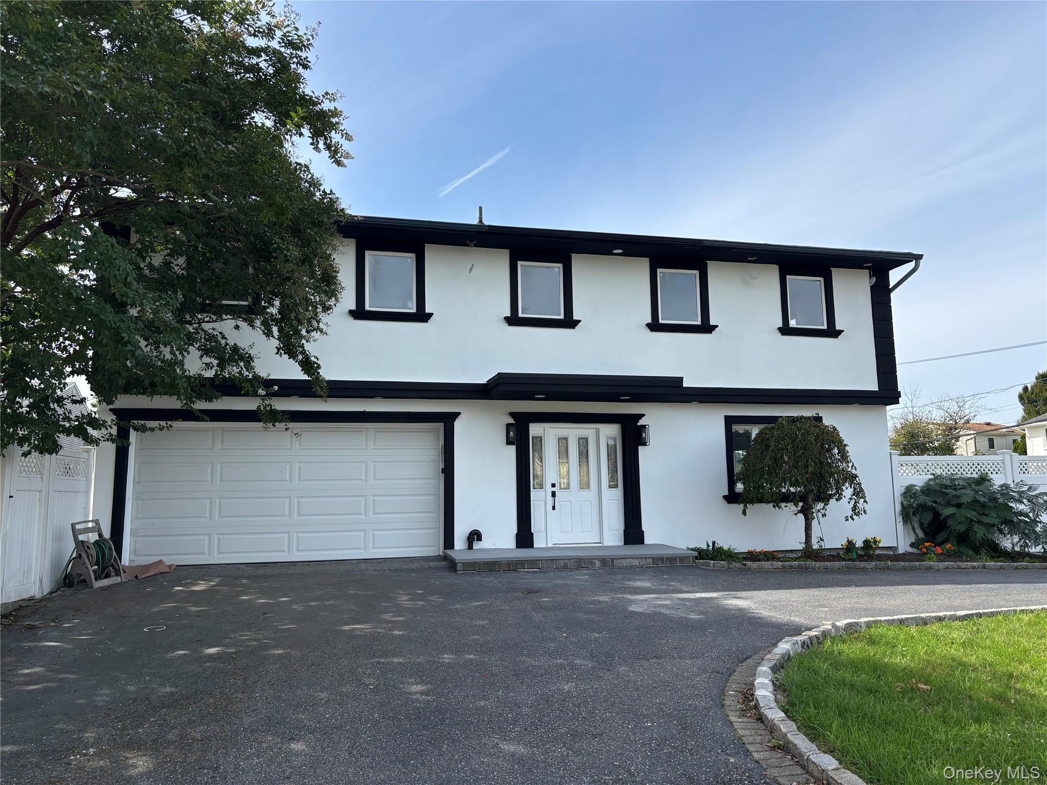 View of front of home featuring stucco siding, asphalt driveway, and a garage