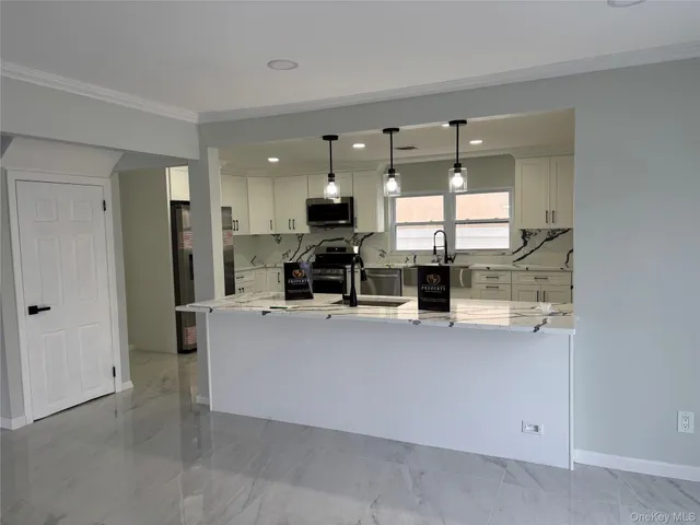 a kitchen with stainless steel appliances kitchen island granite countertop a sink and a stove