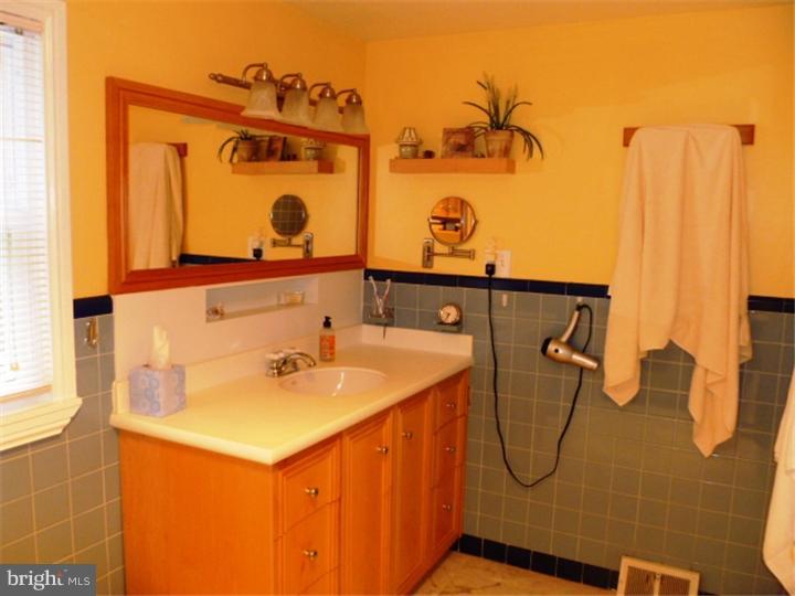 10 Briar Road Cherry Hill, NJ 08034 - Photo 15 of 25 a bathroom with a sink and mirror with bathtub