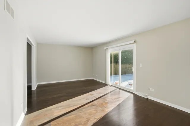 an empty room with wooden floor and sliding door