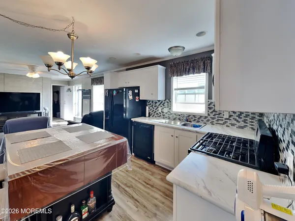 a kitchen with a table chairs and white cabinets