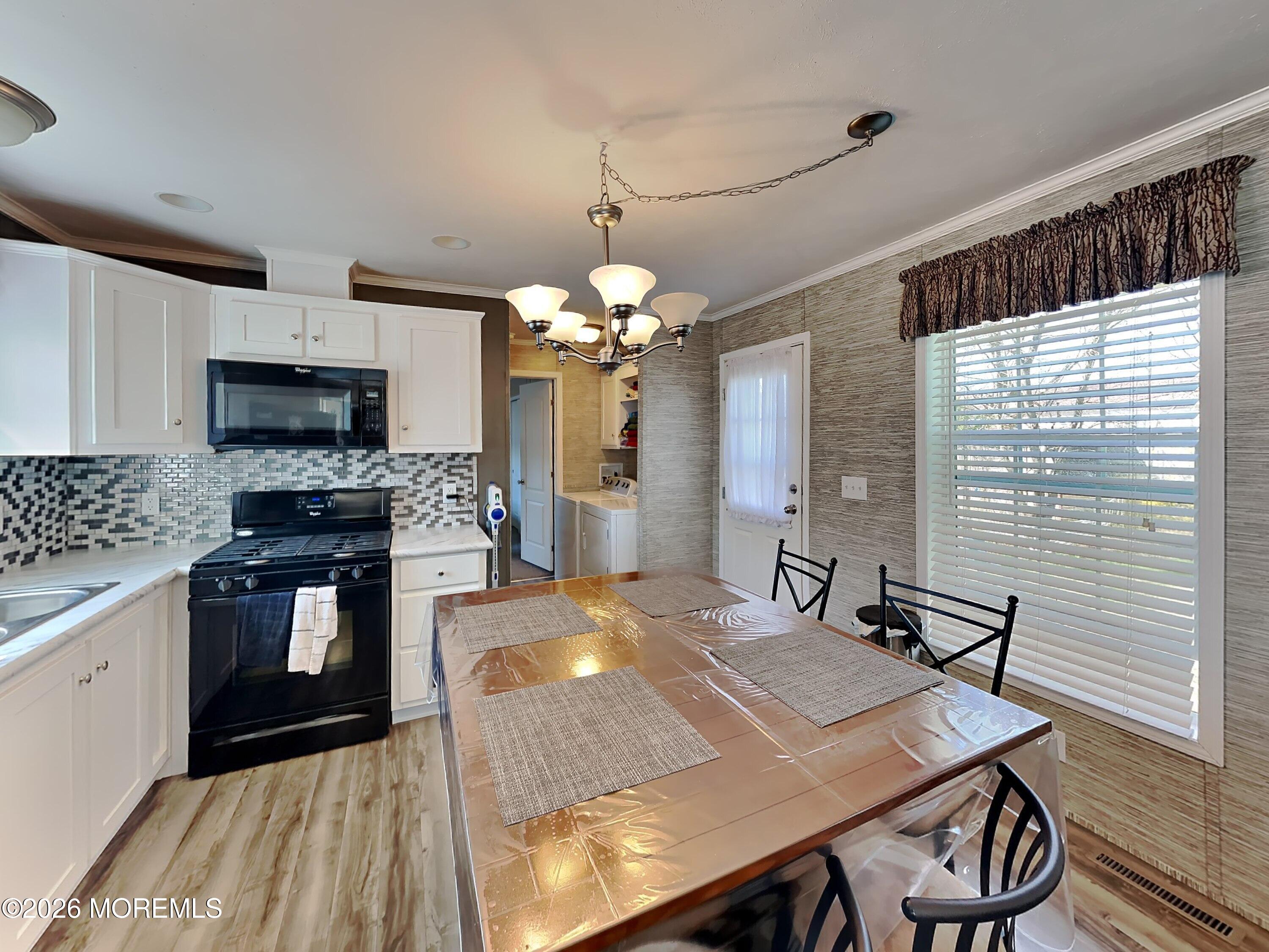 411 4th Street Jackson, NJ 08527 - Photo 7 of 15 a kitchen with a table chairs sink and microwave