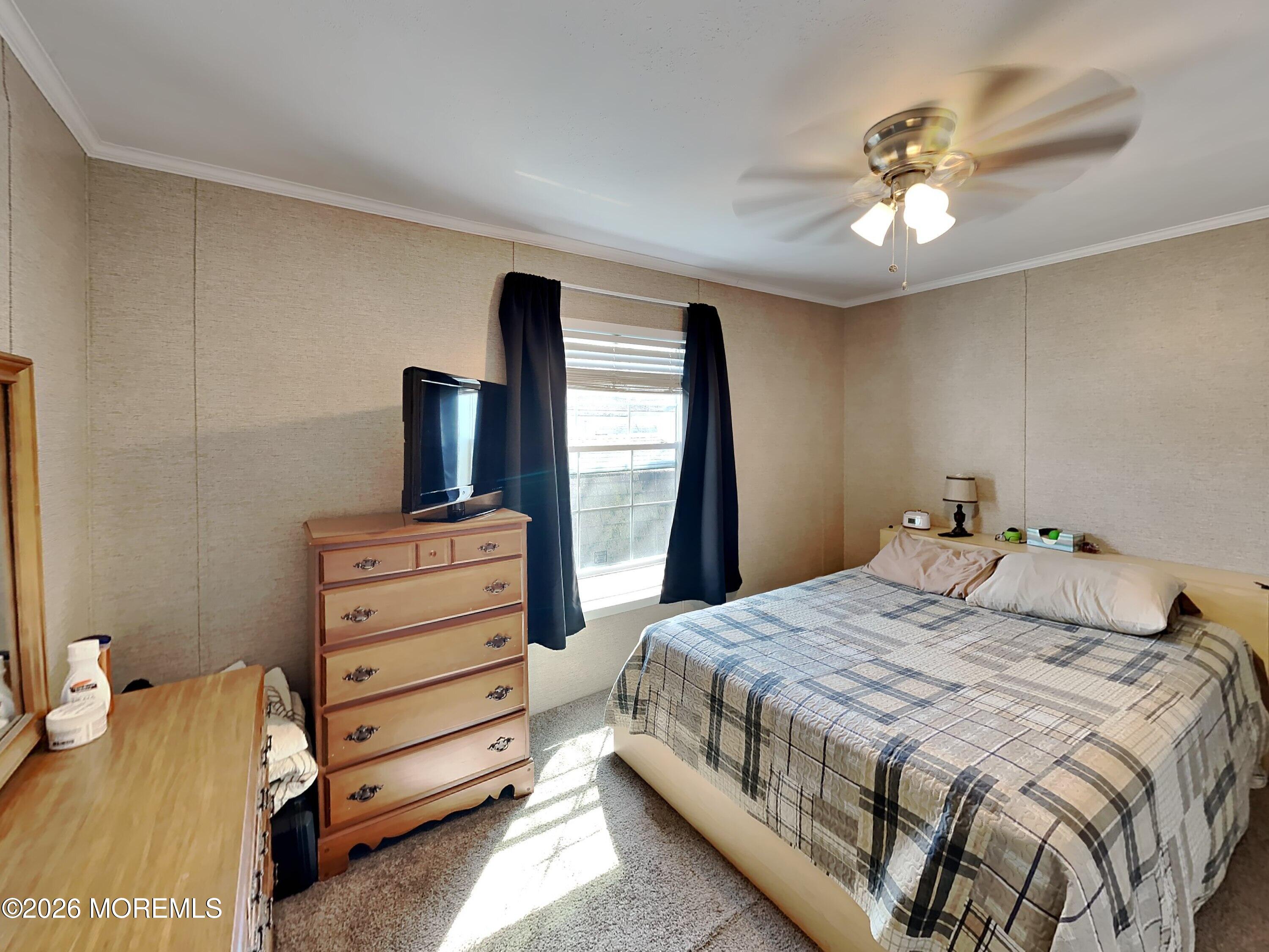 411 4th Street Jackson, NJ 08527 - Photo 10 of 15 a bedroom with a bed and a chandelier