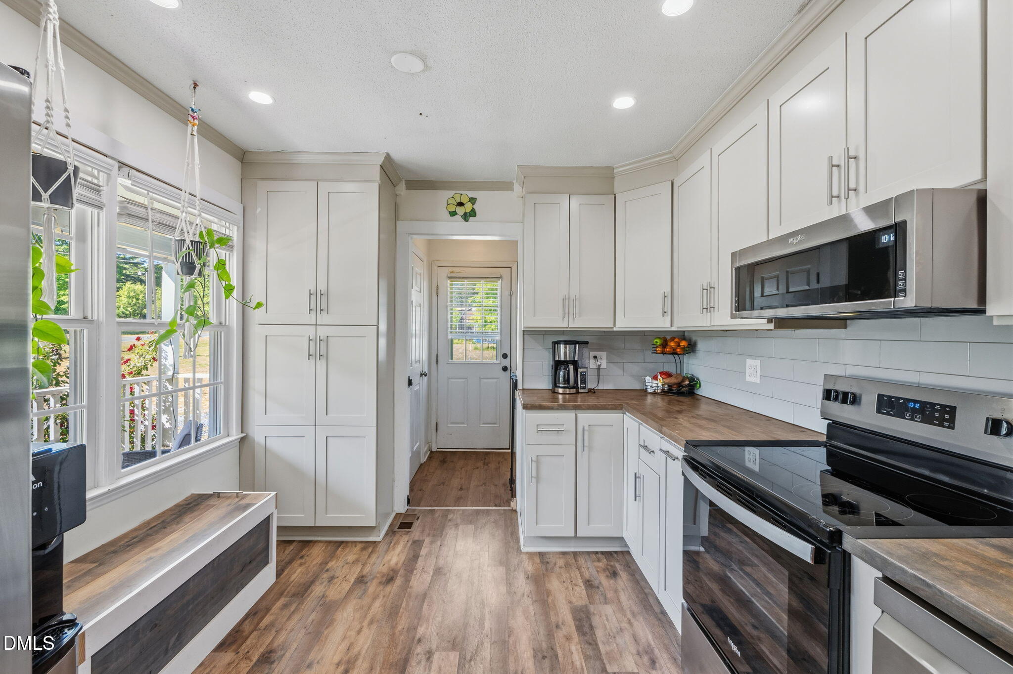 107 East F Street Butner, NC 27509 - Photo 11 of 47 a kitchen with a sink wooden floor and stainless steel appliances