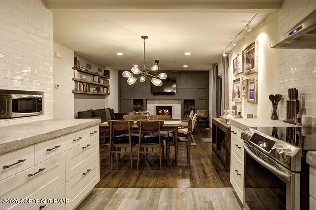 137 Indian Trail Road Jim Thorpe, PA 18229 - Photo 2 of 12 a kitchen with stainless steel appliances kitchen island granite countertop a stove top oven a sink a dining table and chairs with wooden floor