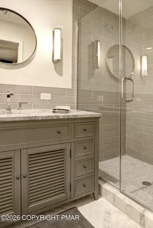 a bathroom with a double vanity sink mirror and shower